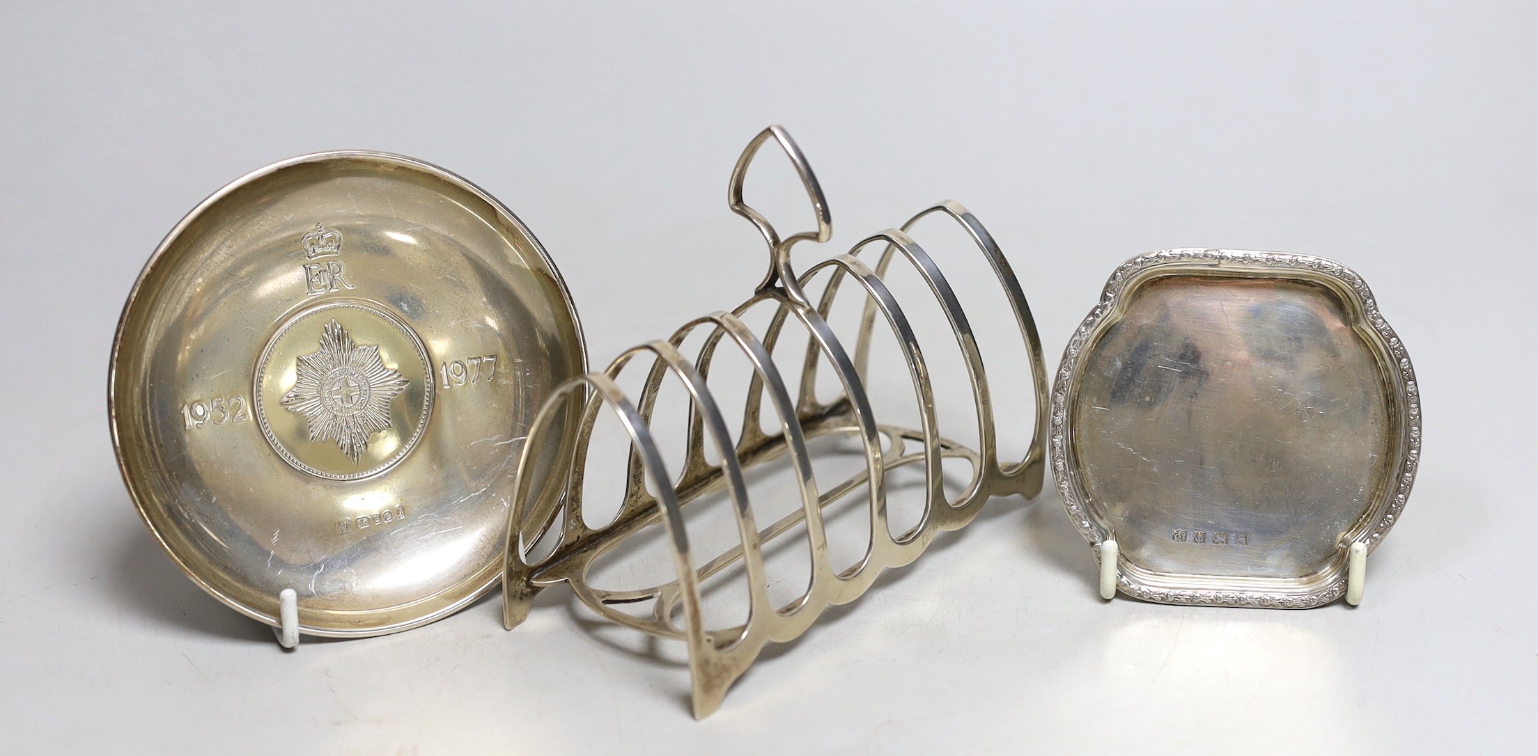 A George V silver seven bar toast rack by William Hutton & Sons, 12.2cm and two silver small pin dishes.